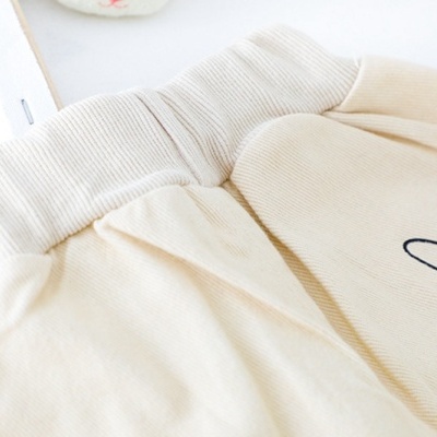 Conjunto de camisola de malha com flores e calças para menina. Roupas coloridas e giras para crianças