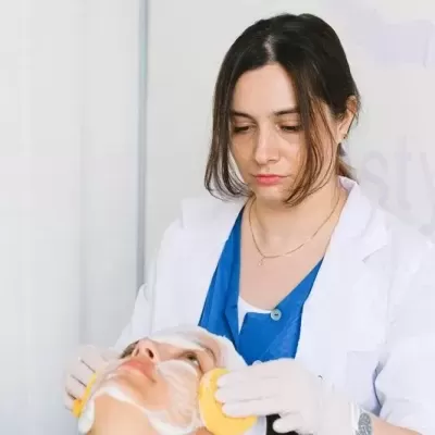 Profissional a limpar a pele de uma cliente antes de um procedimento estético
