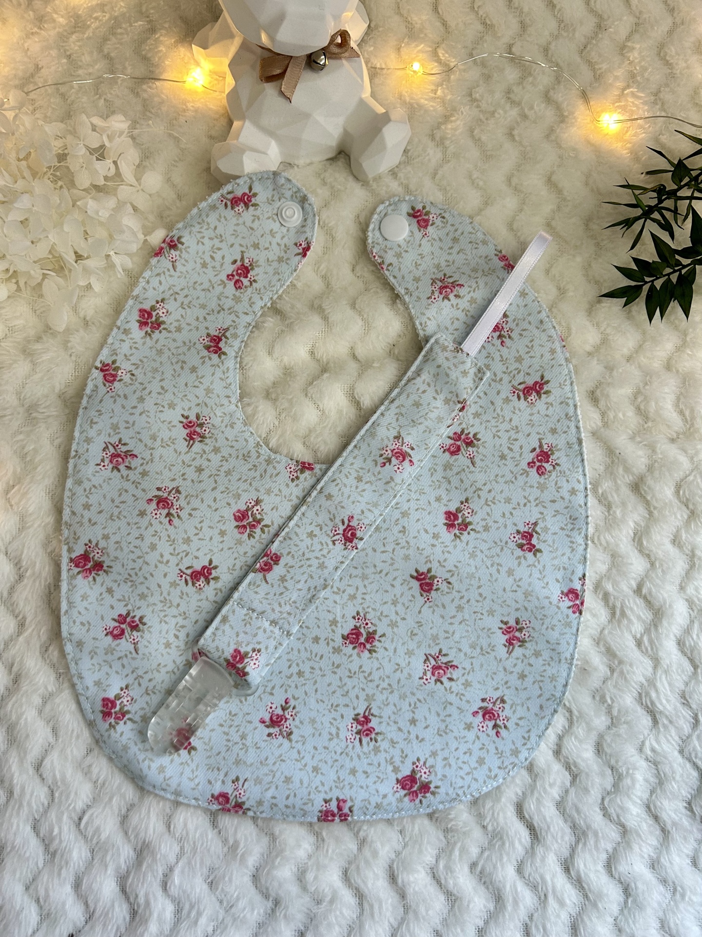 CONJUNTO BABETE E PRENDE CHUPETA FLORES COM FUNDO AZUL