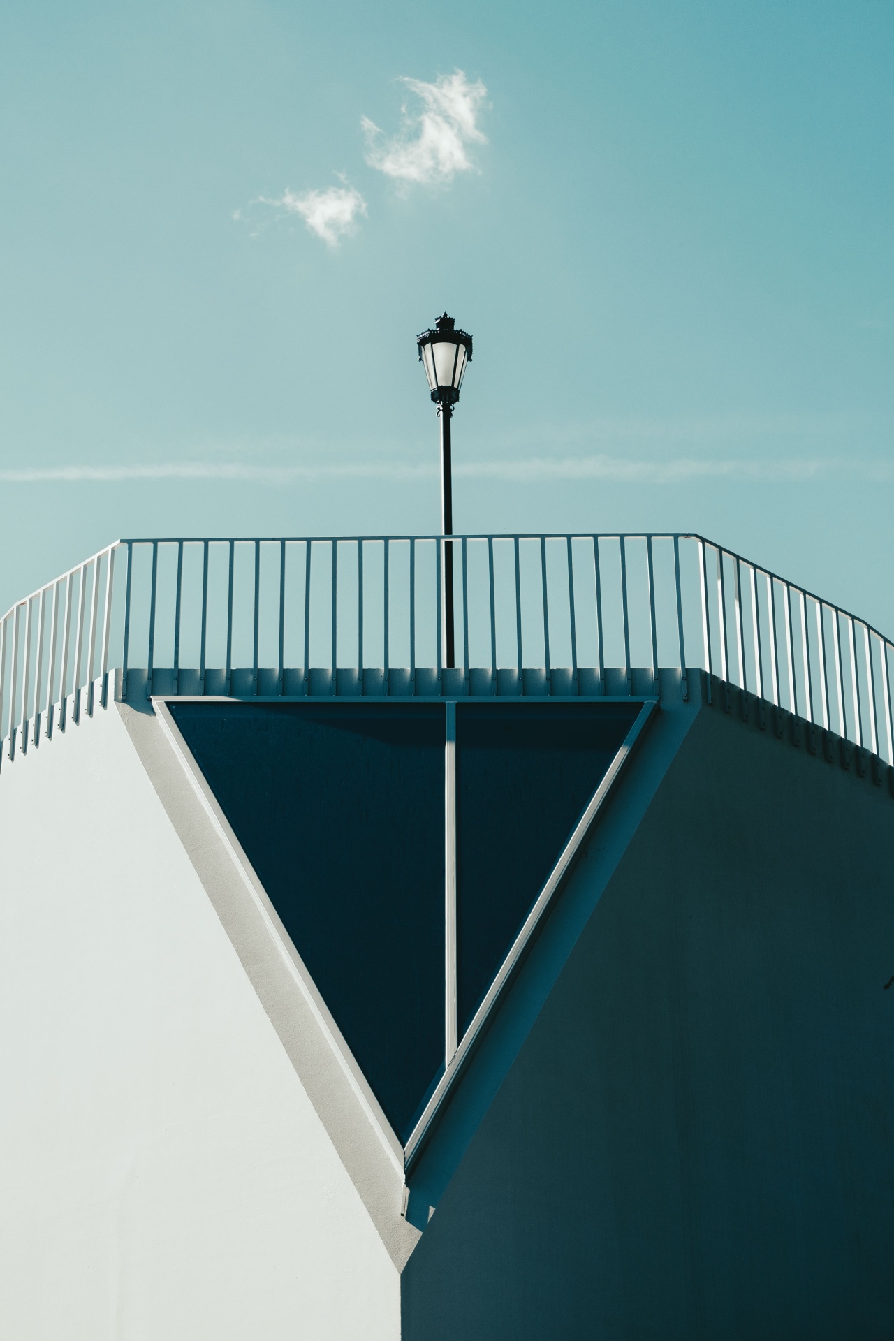 Fotografia de arquitetura de Isabel Moreira com composição geométrica, linhas, candeeiro e céu azul.