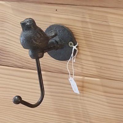 Cabide em ferro forjado com um passarinho.