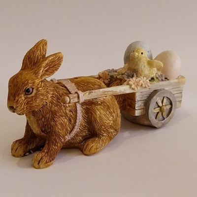 Coelho de Páscoa com um carrinho dois ovos e um pintainho.