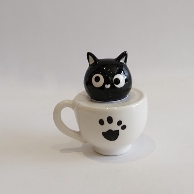 Gato preto e branco na chávena.