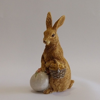 Coelho castanho com um ovo e pintainhos.