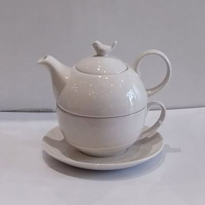 Bule e chávena com passarinho branco.