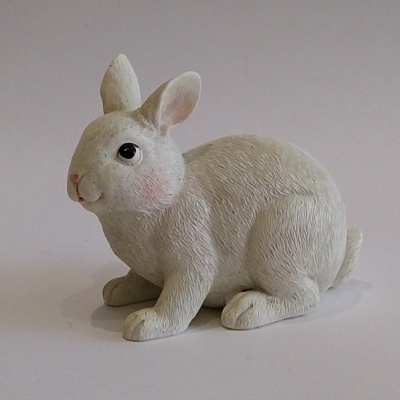 Coelho branco deitado.