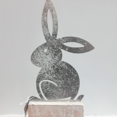 Coelho em metal com base em madeira.